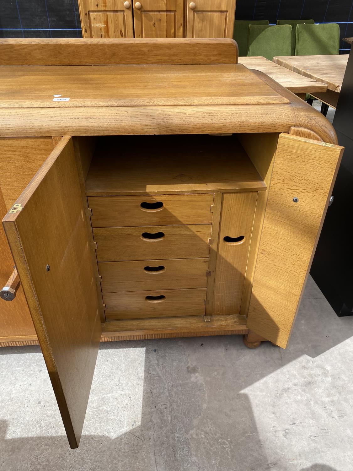 AN OAK E-GOMME SIDEBOARD DATED 1939 ENCLOSING CURVED END CUPBOARDS, TWO PAIRS OF CUPBOARDS WITH FOUR - Image 7 of 9