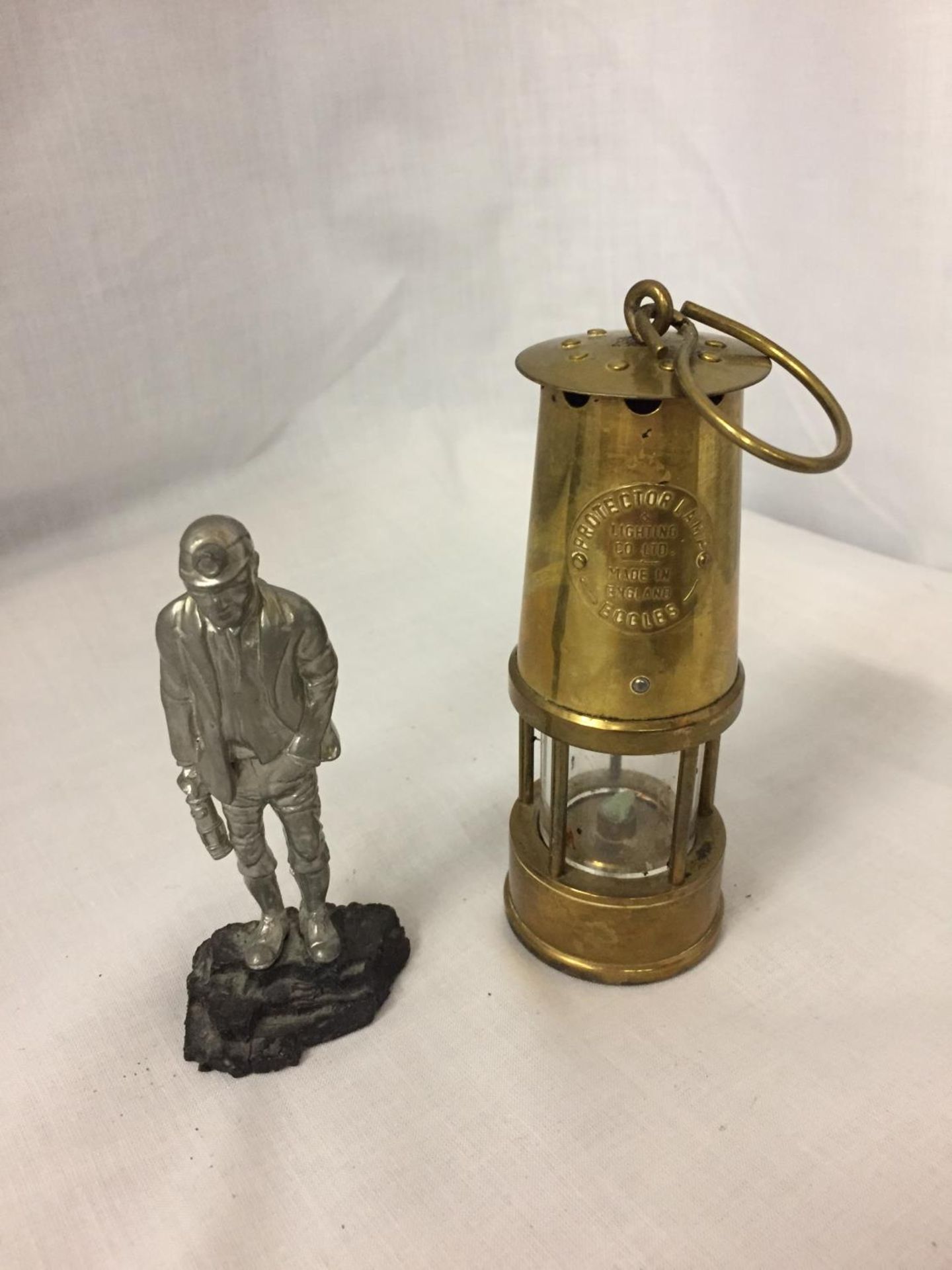 A BRASS MINATURE MINERS PROTECTION LAMP ECCLES AND A FIGURE OF A MINER