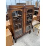 AN EARLY 20TH CENTURY TWO DOOR GLAZED AND LEADED CABINET, 36" WIDE