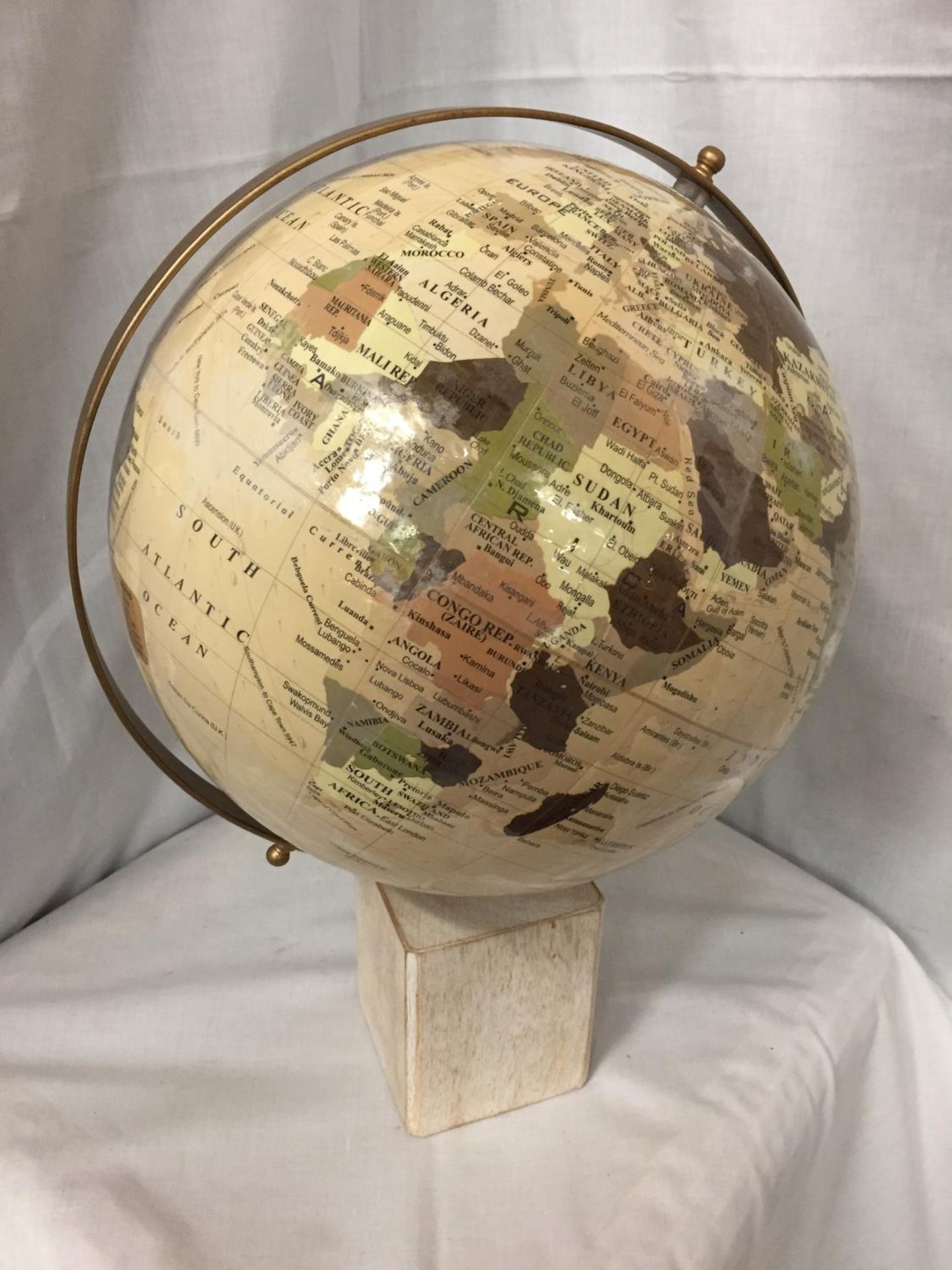 A LARGE GLOBE ON A WOODEN BASE