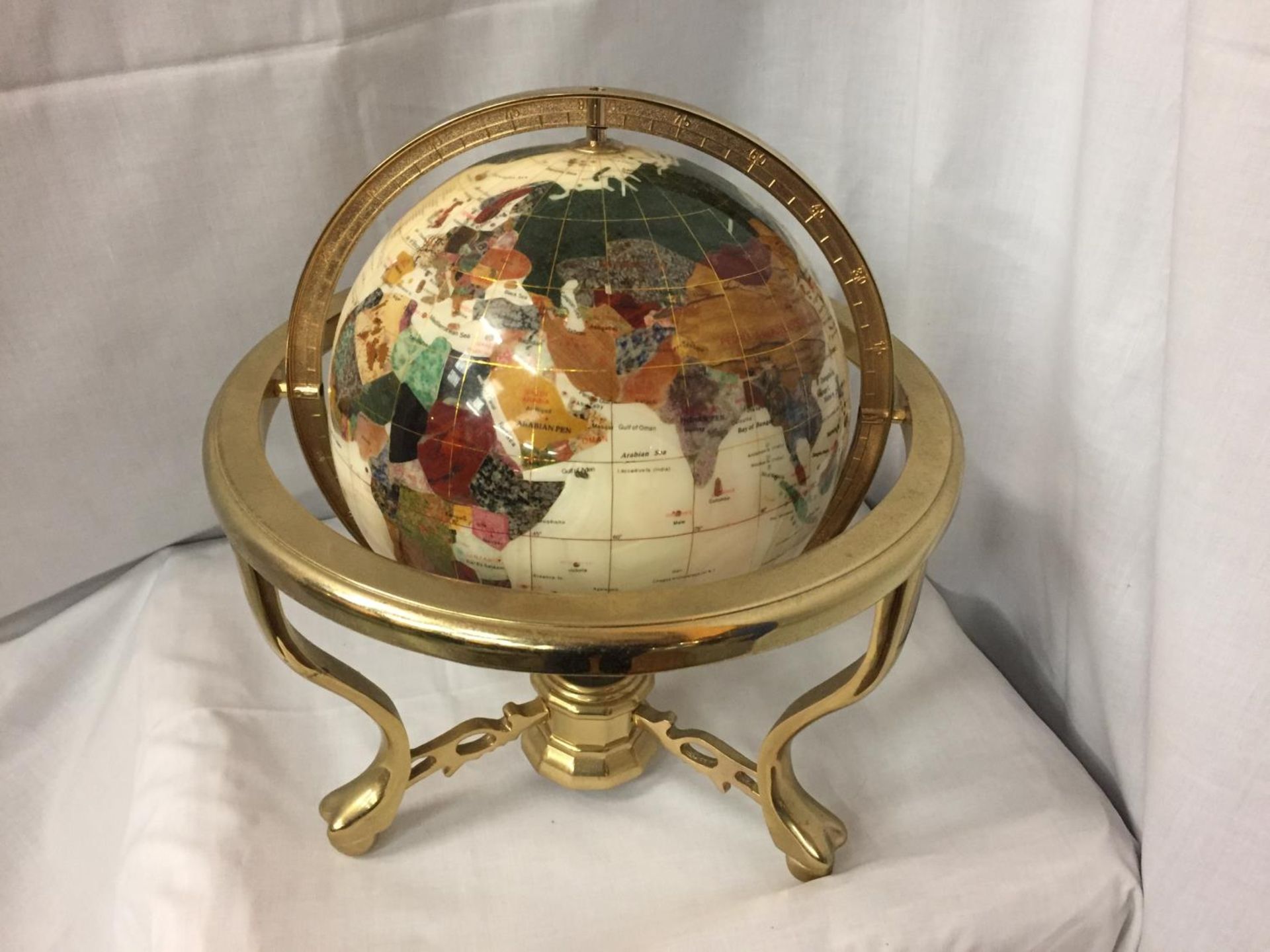 A GEM STONE AND PEARLISED GLOBE ON BRASS STAND 32CM HIGH