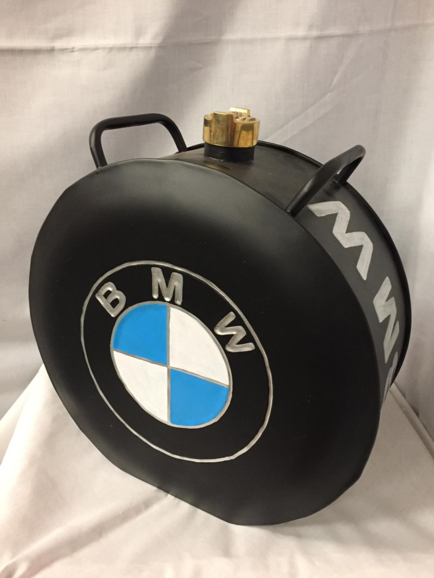 A BLACK BMW PETROL CAN WITH A BRASS TOP