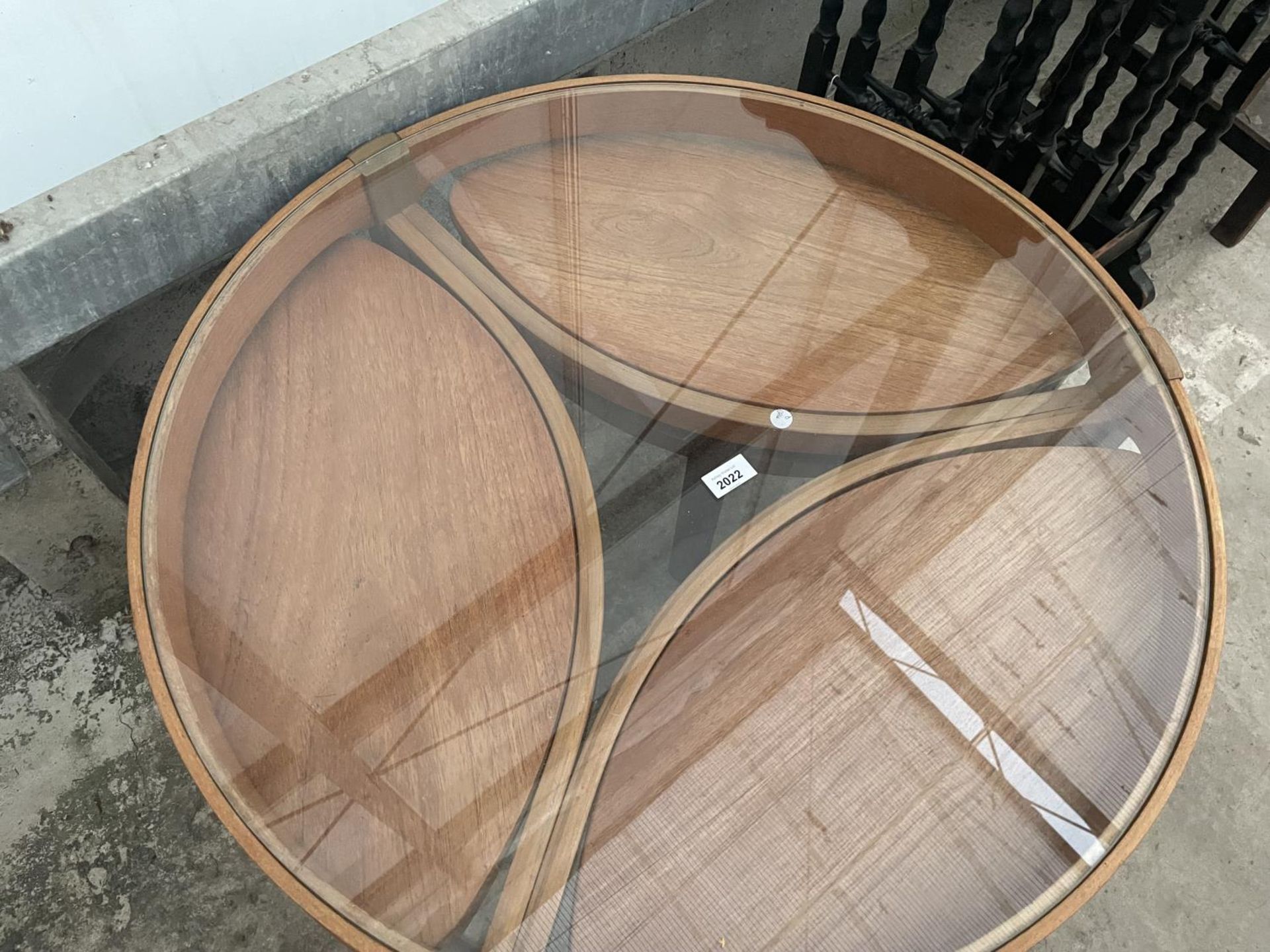 A RETRO TEAK CIRCULAR NEST OF FOUR TABLES WITH GLASS TOP AND THREE UNDER TABLES, OVAL IN SHAPE, - Image 2 of 7