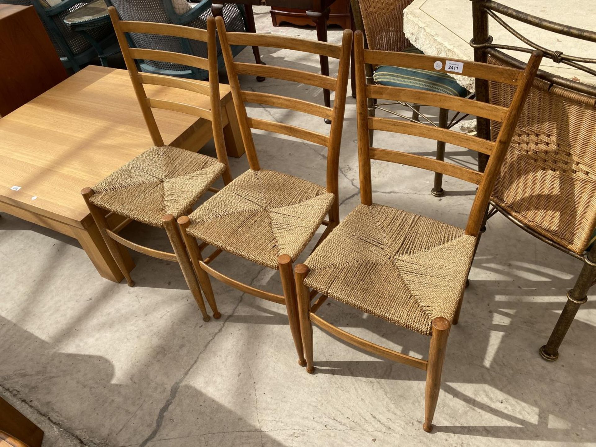 A SET OF THREE RETRO BEECH RATTAN SEATED CHAIRS WITH LADDERBACKS