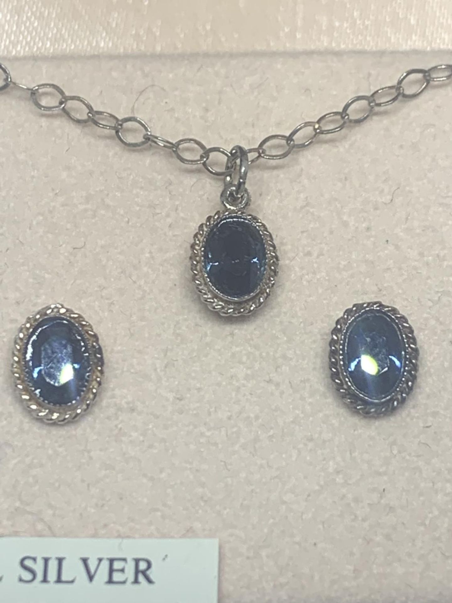 A BOXED SILVER NECKLACE AND EARRING SET WITH BLUE STONES SURROUNDED BY CLEAR STONE CHIPS - Image 2 of 2
