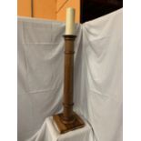 A TALL WOODEN CANDLE STAND WITH CANDLE - STAND HEIGHT APPROXIMATELY 105CM