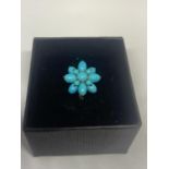 A 9 CARAT GOLD RING WITH BLUE NAVAJO STYLE STONES IN A FLOWER DESIGN WITH A PRESENTATION BOX
