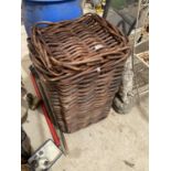 A LARGE LIDDED WICKER LOG/LAUNDRY BASKET