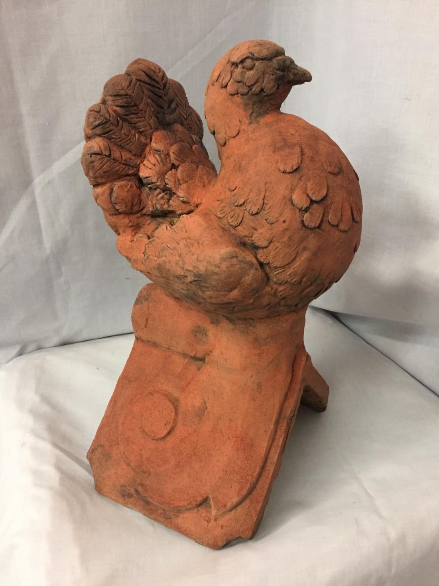 A TERRACOTTA ROOF TILE FINIAL OF A DOVE