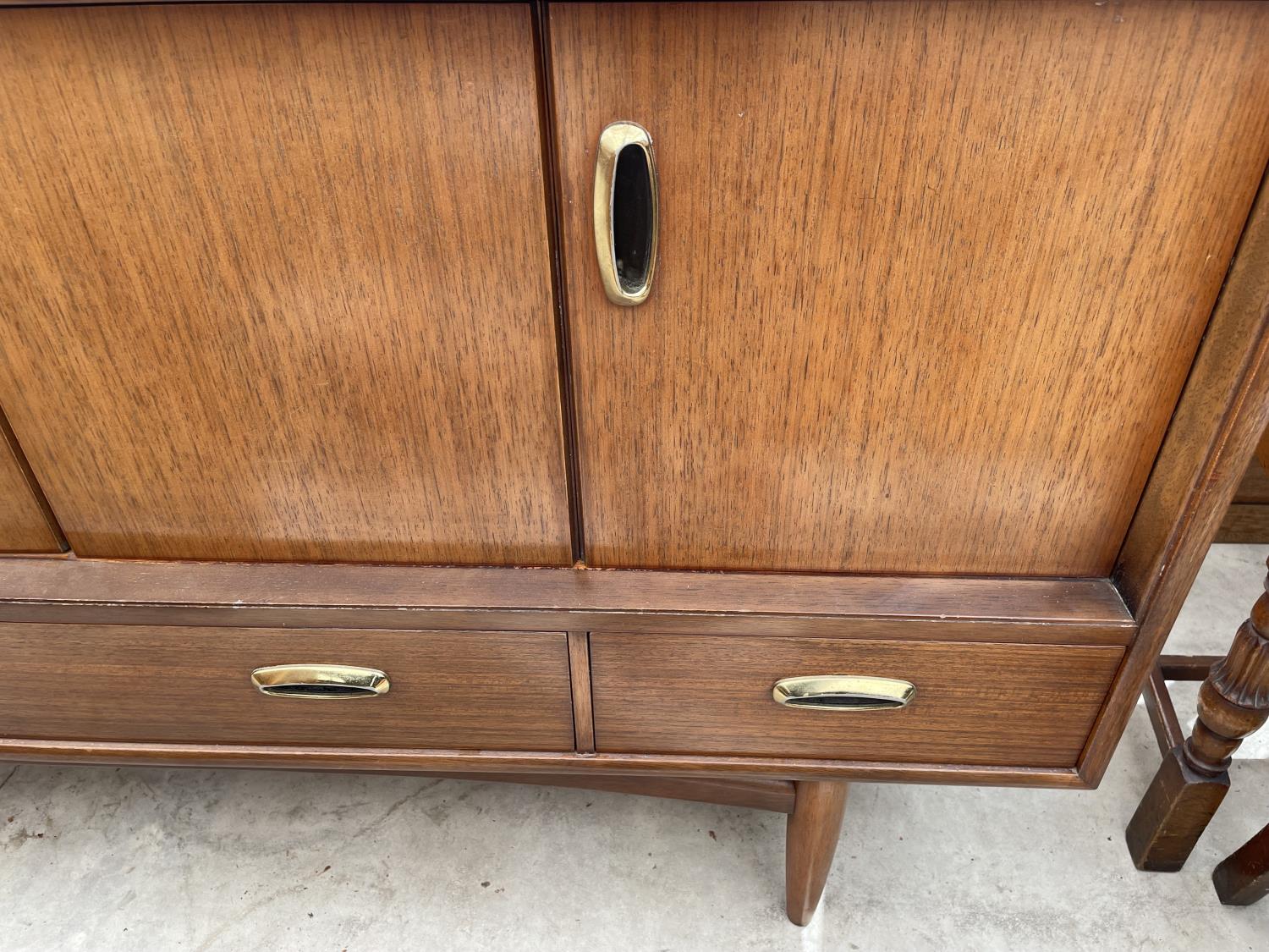 A RETRO TEAK G-PLAN SIDEBOARD ENCLOSING BI-FOLD DOORS AND THREE DRAWERS TO THE BASE, 57" WIDE - Image 5 of 7