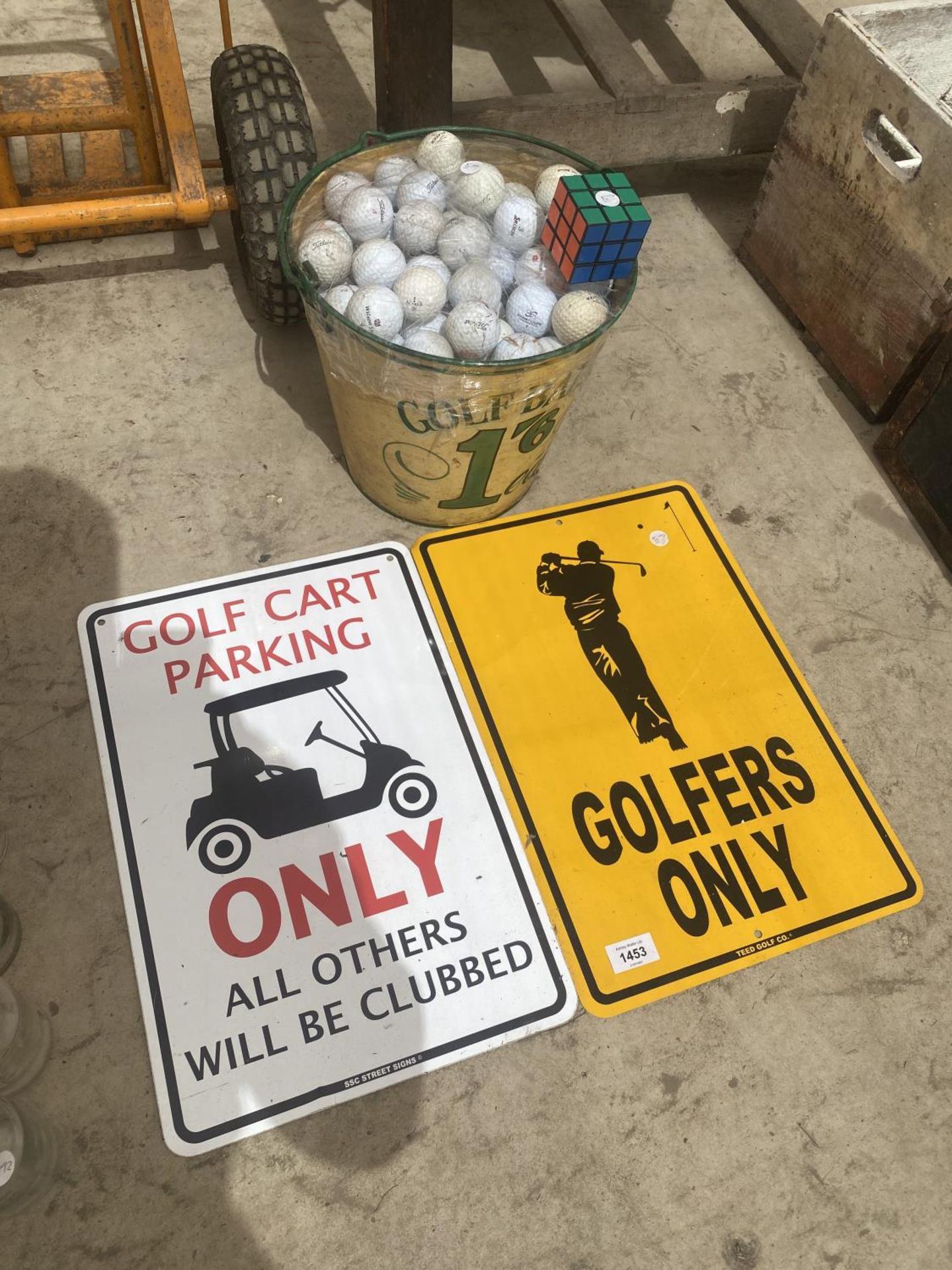 A LARGE QUANTITY OF GOLF BALLS, TWO GOLF RELATED SIGNS AND A GOLF BUCKET