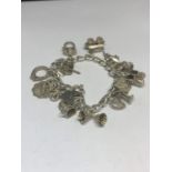 A SILVER CHARM BRACELET WITH FOURTEEN CHARMS TO INCLUDE HEARTS, BOOTIES, RINGS, BALLERINA, BELLS ETC