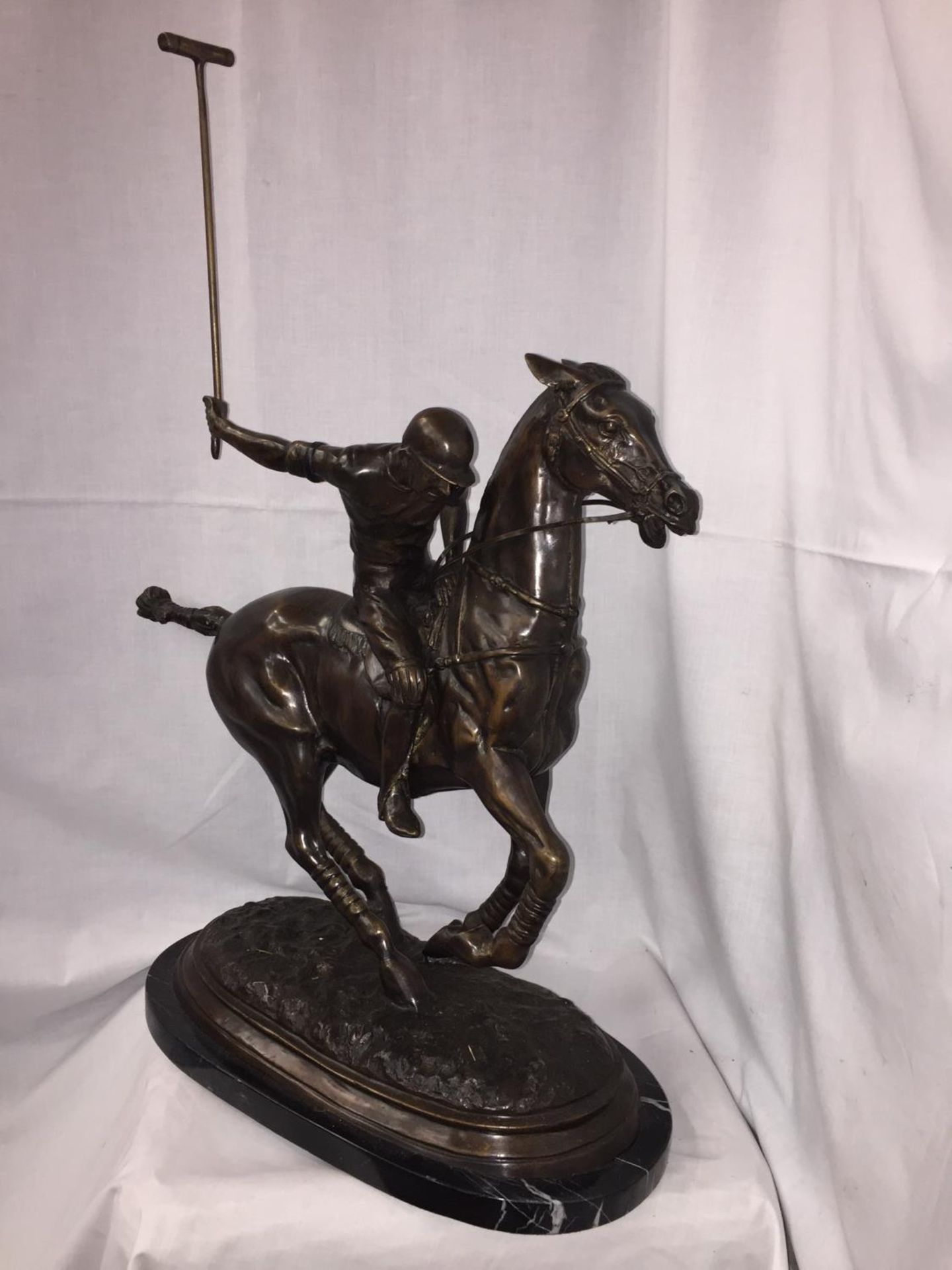 A LARGE BRONZE STATUE OF A POLO PLAYER ON A MARBLE BASE 54CM LENGTH (TAIL TO NOSE) X 60CM HEIGHT