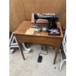 A SEWING TABLE ENCLOSING A VINTAGE SINGER SEWING MACHINE COMPLETE WITH SINGER WORK LAMP AND