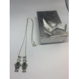 A SILVER NECKLACE WITH TWO SILVER AND GREEN STONE ROBOT PENDANTS WITH A PRESENTATION BOX