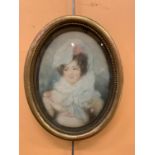 A FRAMED OVAL PICTURE OF A GIRL