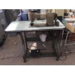 A BROTHER INDUSTRIES LTD INDUSTRIAL SEWING MACHINE AND TREDDLE TABLE