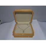 AN 18 CARAT WHITE GOLD NECKLACE WITH A PENDANT INCORPORATING FOUR DIAMONDS WITH A 50CM CHAIN IN A