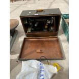A VINTAGE SINGER SEWING MACHINE WITH LEATHER EFFECT CASE