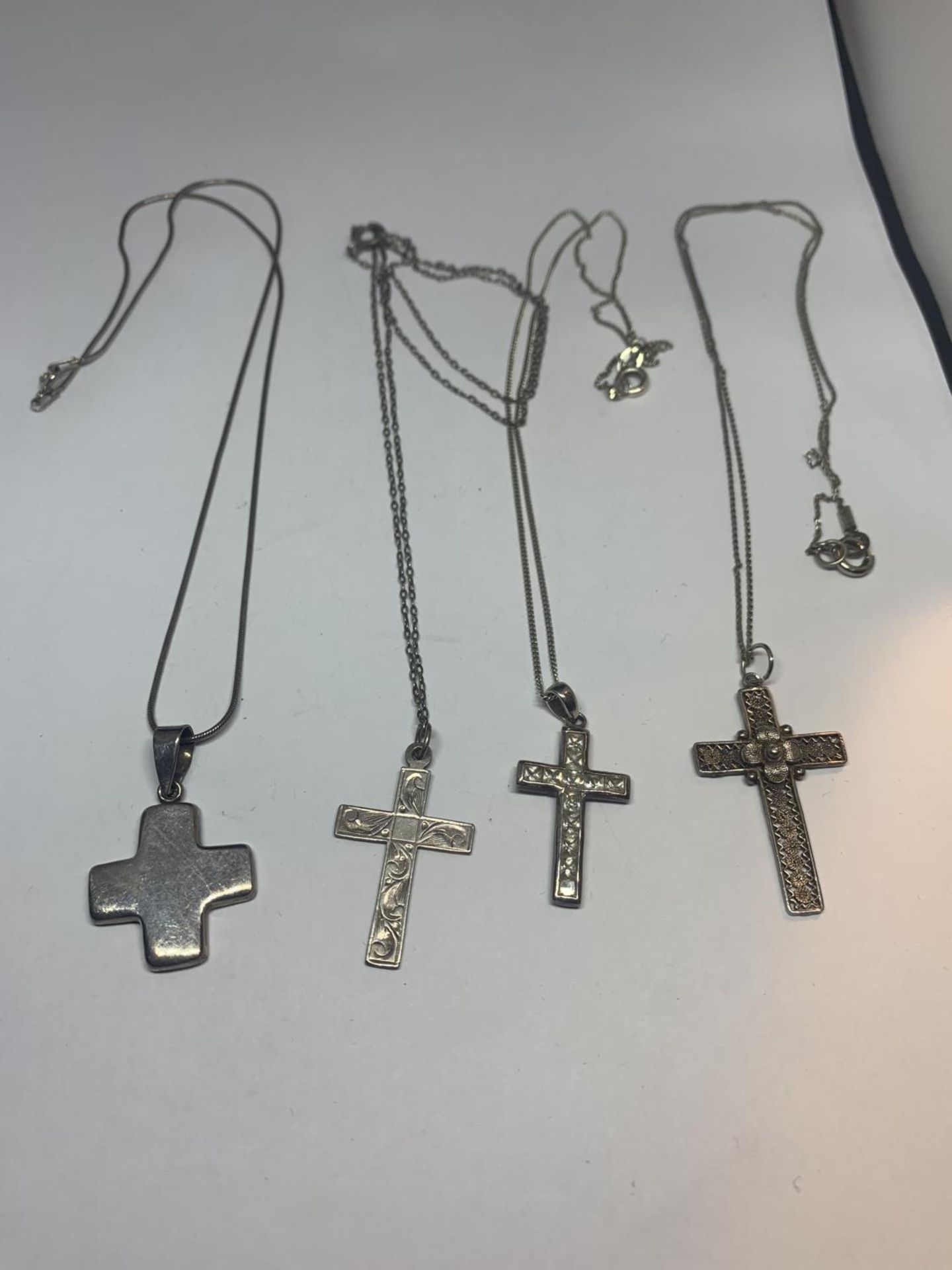 FOUR SILVER NECKLACES WITH CROSS PENDANTS IN A PRESENTATION BOX