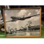 A FRAMED BLACK AND WHITE PHOTOGRAPH ON AN AEROPLANE TAKING OFF