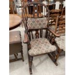 A REPRODUCTION WINDSOR ROCKING CHAIR WITH TURNED UPRIGHTS, BEARING LABEL 'R.E.FORSTER, WARRINGTON'