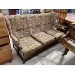 A PARKER KNOLL STYLE WINGED THREE SEATER COTTAGE SETTEE