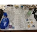 A LARGE QUANTITY OF GLASSWARE TO INCLUDE COLOURED DISHES, BOTTLES ETC