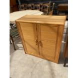 A MODERN PINE TWO DOOR CUPBOARD, 32" WIDE