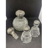 THREE SILVER TOPPED GLASS BOTTLES AND A STOPPER