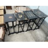 A NEST OF FOUR EBONISED AND PAPIER MACHE TABLES, THREE TABLES BEARING HUNTING IMAGE AND ONE WITH