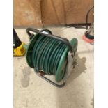 TWO GARDEN RAKES AND A HOSE REEL