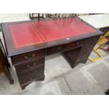 A REPRODUCTION MAHOGANY KNEEHOLE DESK OF NINE DRAWERS, 54" X 27"