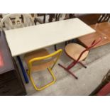 A MODERN DOUBLE CHILDS DESK ON BLUE BASE AND TWO CHAIRS, ONE RED, ONE YELLOW