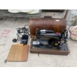 A VINTAGE SINGER SEWING MACHINE WITH WORK LIGHT AND WOODEN CARRY CASE