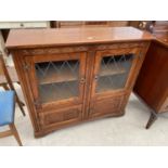 A STANLEY WOOD OAK GLAZED AND LEADED BOOKCASE WITH CUPBOARDS TO THE BASE, 42" WIDE