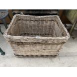 A LARGE WICKER LOG BASKET WITH ROPE DETAIL