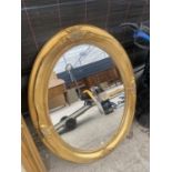 A DECORATIVE OVAL GILT FRAMED MIRROR