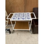A VINTAGE RETRO TEA TROLLEY DECORATED WITH DELFT TILE EFFECT AND REVERSIBLE TIERS