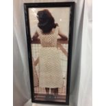 A LARGE BLACK FRAMED ORIGINAL KODAK PRINT OF A 1940'S LADY IN A POLKA DOT DRESS AND SEAMED STOCKINGS