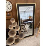 A MODERN GILT AND BLACK FRAMED BEVELED EDGE MIRROR AND A DECORATIVE WALL MOUNTING