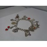 A SILVER CHARM BRACELET WITH 13 CHARMS