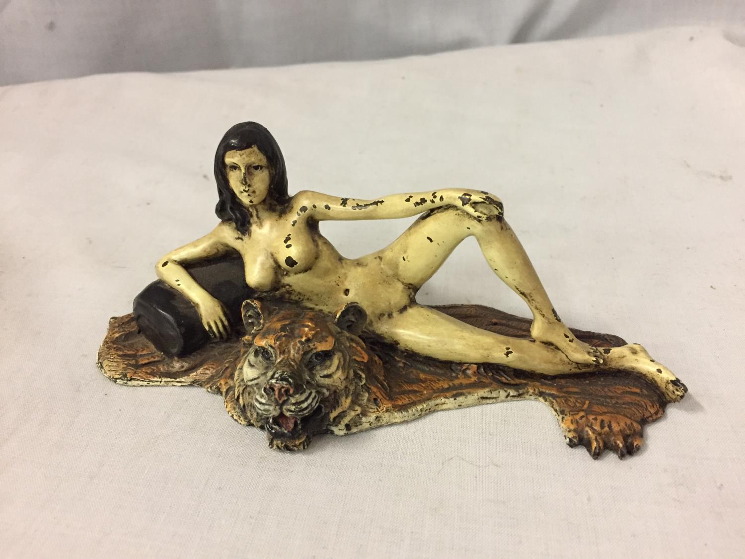 A COLD PAINTED BRONZE FIGURINE OF A NUDE LADY LYING ON A TIGER RUG