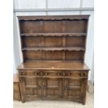 AN OAK JACOBEAN STYLE DRESSER COMPLETE WITH PLATE RACK, THE BASE ENCLOSING THREE DRAWERS AND THREE