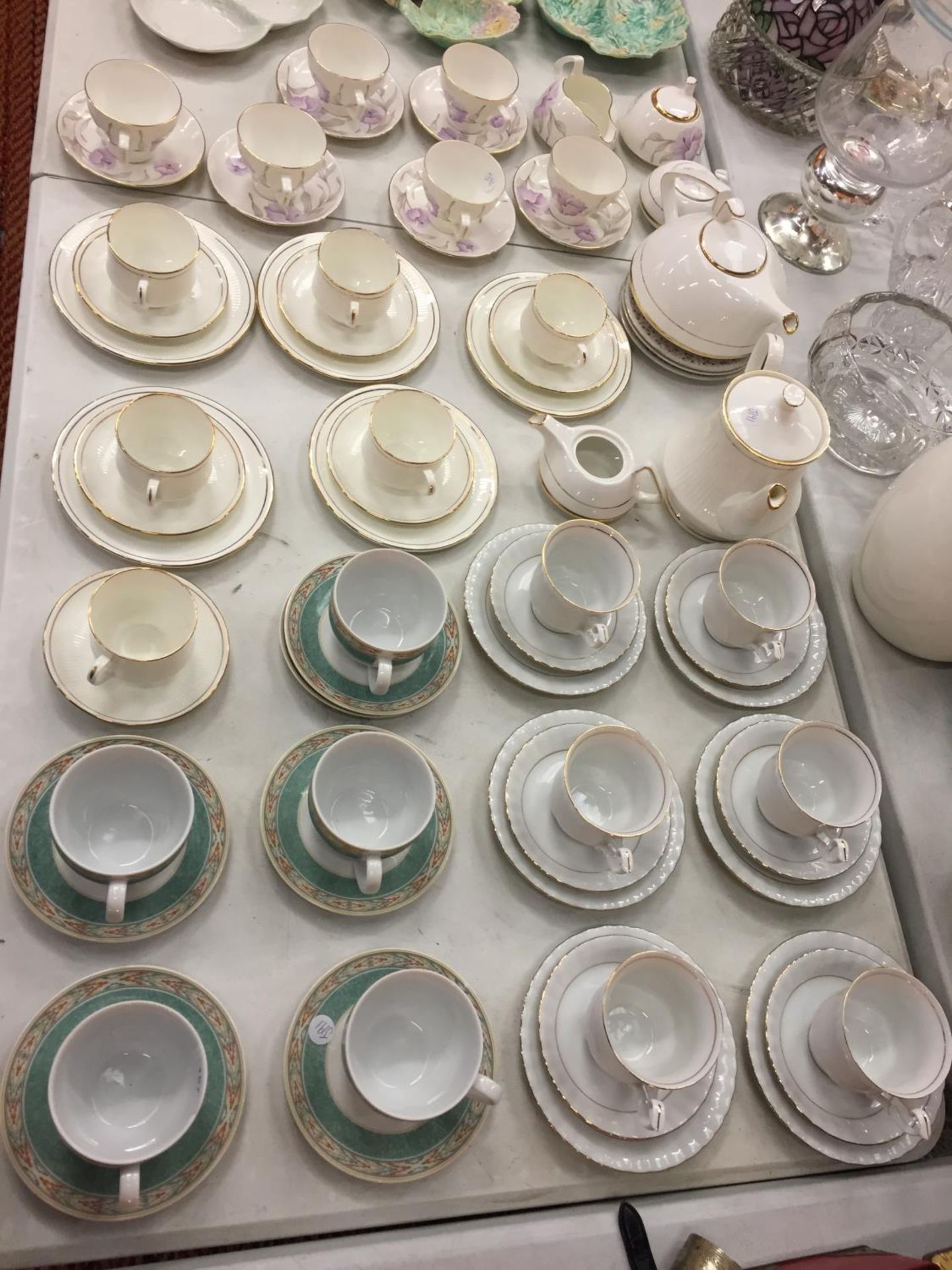 A LARGE COLLECTION OF VARIOUS TEA CUPS AND SAUCERS OF VARIOUS DESIGNS AND TWO TEAPOTS