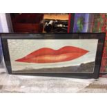 A FRAMED MODERN PICTURE OF A PAIR OF RED PAINTED LIPS ABOVE A HORIZON LANDSCAPE SIZE 102CM X 52CM