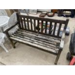 A WOODEN SLATTED GARDEN BENCH