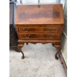 A REPRODUCTION WALNUT AND CROSSBANDED BUREAU WITH FITTED INTERIORS AND CABRIOLE LEGS, 27" WIDE