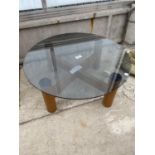 A RETRO CIRCULAR COFFEE TABLE ON X-FRAME WITH SMOKED GLASS TOP, 24" DIAMETER