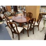 A QUEEN ANNE STYLE EXTENDING DINING TABLE ON CABRIOLE LEGS AND EIGHT DINING CHAIRS, TWO BEING